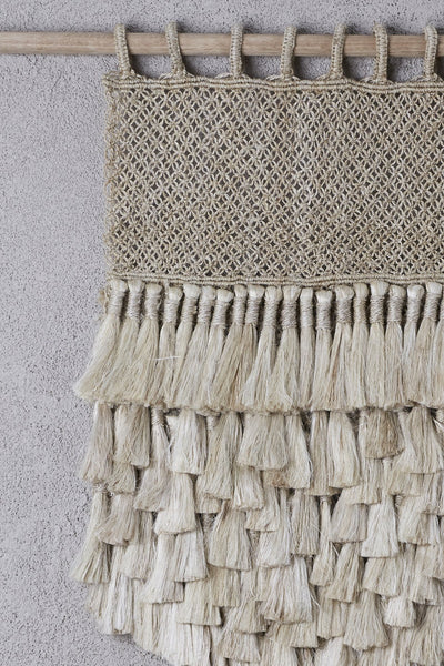 detail of jute wall hanging with tassels on bamboo hanging rod